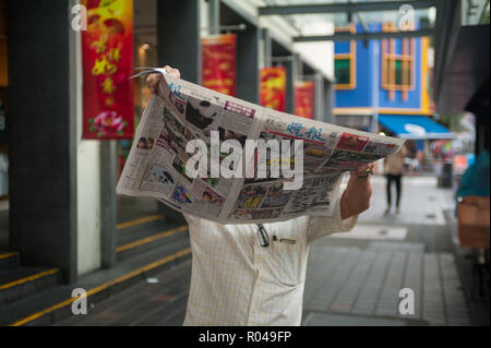 Republik Singapur, Mann liest Zeitung in Chinatown Stockfoto