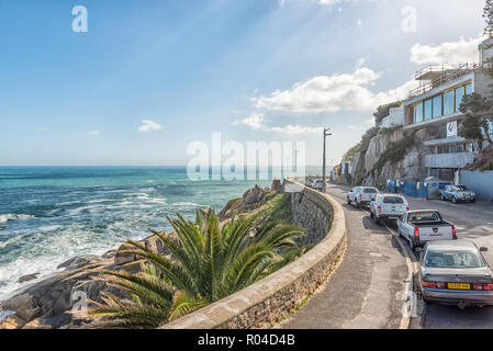 Kapstadt, Südafrika, 17. AUGUST 2018: Ein Blick auf die Victoria Road in Bantry Bay in Kapstadt in der Western Cape Provinz. Der Atlantische Ozean und Fahrzeuge Stockfoto