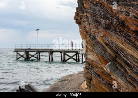 Die berühmte zweite Tal Cliff mit einem selektiven weichzeichner der Mole im Hintergrund an einem bewölkten Tag auf der Fleurieu Peninsula South Austr Stockfoto