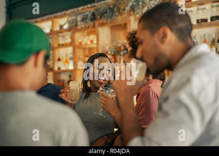 Diverse junge Freunde zusammen lachen bei Getränken in der Bar Stockfoto