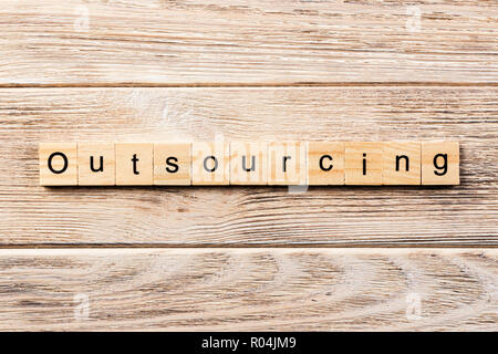 Outsourcing Wort auf Holz Block geschrieben. Outsourcing text auf Tisch, Konzept. Stockfoto