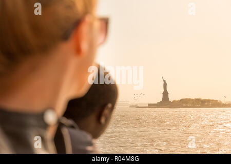 Touristen an der Freiheitsstatue Silhouette Sonnenuntergang von der Staten Island Ferry, New York City, USA Stockfoto