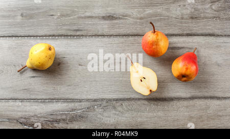 Table Top Aussicht, reife Birnen, halbiert, auf grau Holzschreibtisch. Stockfoto