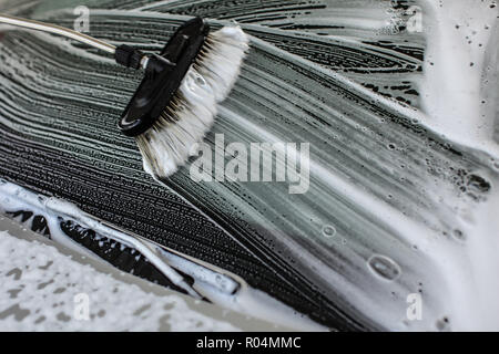 Bürste aus Anschläge in white Shampoo und Schaum auf ein Fenster der Auto in Waschstraße gewaschen. Stockfoto