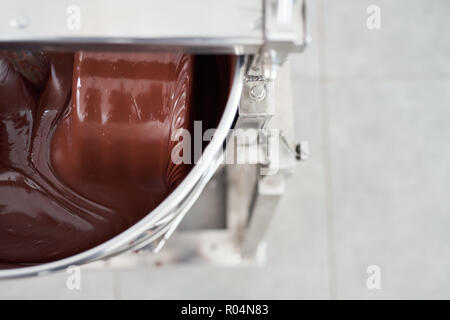 Geschmolzene Schokolade gerührt sein in einem Edelstahl Mixer Stockfoto