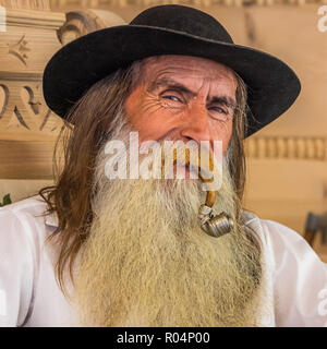 Eine ältere Polnische Mann mit Bart und Pfeife, die traditionelle Kleidung in der Stadt Zakopone, Polen, Europa Stockfoto