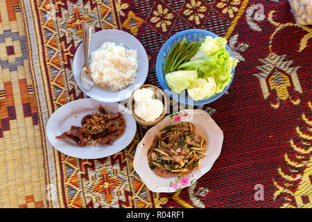 Traditionelle thailändische pikante Mittagessen mit Hühnchen, Schweinefleisch und klebriger Reis auf einem Rush Mat Stockfoto