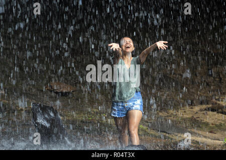 Glückliche Frau genießen das Wasser fällt aus tropischen Wasserfall, Thailand Stockfoto