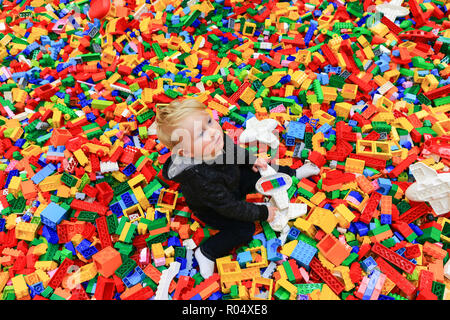 Ein kleiner Junge, der das Spielen mit LEGO Steinen Stockfoto