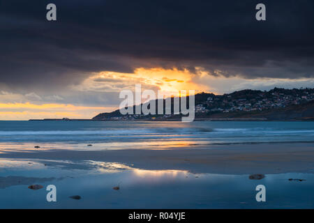 Charmouth, Dorset, Großbritannien. Am 1. November 2018. UK Wetter. Dunkle Wolken droht in den Himmel bei Sonnenuntergang in einem Pool von Wasser am Strand nieder bei Charmouth auf der Jurassic Coast von Dorset in Lyme Regis. Foto: Graham Jagd-/Alamy leben Nachrichten Stockfoto