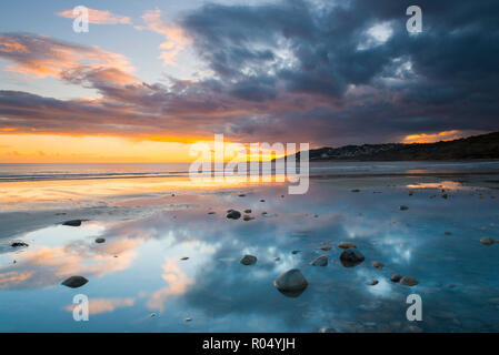 Charmouth, Dorset, Großbritannien. Am 1. November 2018. UK Wetter. Dunkle Wolken droht in den Himmel bei Sonnenuntergang in einem Pool von Wasser am Strand nieder bei Charmouth auf der Jurassic Coast von Dorset in Lyme Regis. Foto: Graham Jagd-/Alamy leben Nachrichten Stockfoto