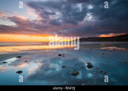 Charmouth, Dorset, Großbritannien. Am 1. November 2018. UK Wetter. Dunkle Wolken droht in den Himmel bei Sonnenuntergang in einem Pool von Wasser am Strand nieder bei Charmouth auf der Jurassic Coast von Dorset in Lyme Regis. Foto: Graham Jagd-/Alamy leben Nachrichten Stockfoto