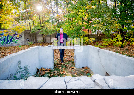 Berlin, Deutschland. Okt, 2018 18. Manfred Wichmann, Kurator der Stiftung Berliner Mauer, steht im Lapidarium der Berliner Mauer Stiftung hinter dem niedrigsten Element der Wachturm der Gartenstraße biegen. Teile der Wände und in andere Teile der DDR-Grenzanlagen werden dort gespeichert. (Dpa-KORR" Stacheldraht und Stein Büste - Berlin sammelt Relikte der Abteilung "ab 02.11.2018) Quelle: Christoph Soeder/dpa/Alamy leben Nachrichten Stockfoto