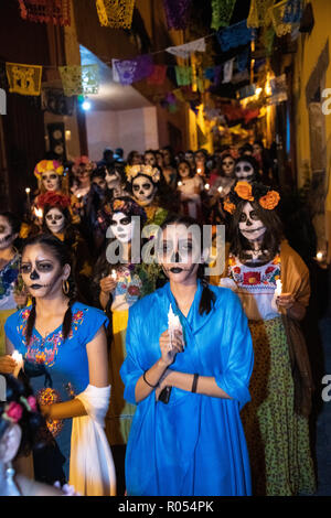 San Miguel de Allende, Mexiko. 1. November 2018. Jungen mexikanischen Frauen in Catrina Kostümen Spaziergang bei Kerzenschein Prozession während der Tag der Toten Festival am 1. November 2018 in San Miguel de Allende, Mexiko. Das Festival ist in Mexiko gefeiert, geliebt zu erinnern, die vergangen. Credit: Planetpix/Alamy leben Nachrichten Stockfoto