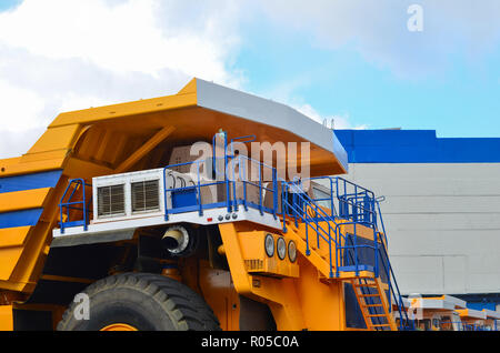 Blick auf die Kabine des weltweit größten gelb Mining Truck vor einem blauen Himmel mit weißen Wolken Stockfoto