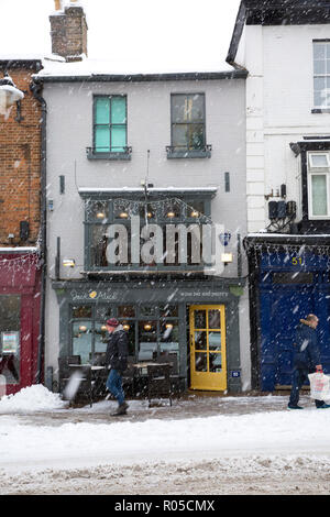 Den Geschäften auf der High Street in der Marktgemeinde Tring, Hertfordshire, England, im Schnee im Winter Blizzard abgedeckt Stockfoto