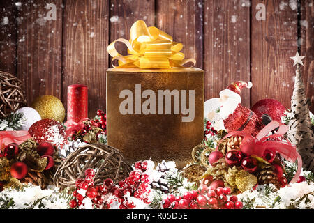 Weihnachten Geschenk Box in der Mitte von Christbaumschmuck auf hölzernen Planken vorgestellt Stockfoto