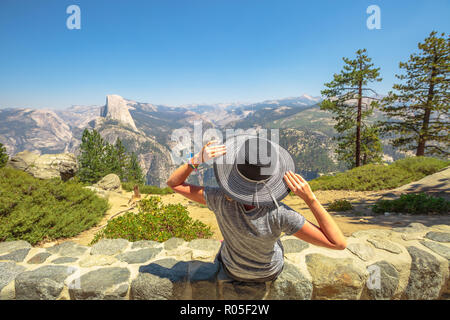 Reisende Frau Entspannung am Glacier Point im Yosemite National Park, Kalifornien, USA. Glacier Point: Half Dome, Liberty Cap, Yosemite Valley und Nevada fallen. Sommer Reisen Urlaub. Stockfoto