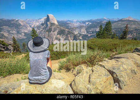 Reisende Frau suchen Panorama am Glacier Point im Yosemite National Park, Kalifornien, USA. Der Blick vom Glacier Point: Half Dome, Liberty Cap, Yosemite Valley und Nevada fallen. Sommer reisen Konzept Stockfoto