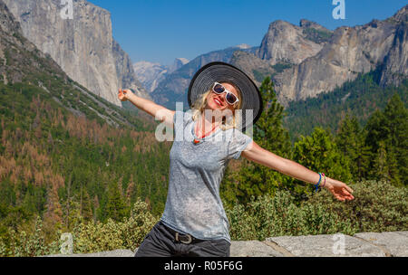 Traveler glückliche Frau genießen Panorama Aussichtspunkt am El Capitan im Yosemite National Park, Kalifornien, USA. Half Dome und Bridalveil Fall von iconic Tunnel anzuzeigen. Amerikanische Feiertage auf der Straße. Stockfoto