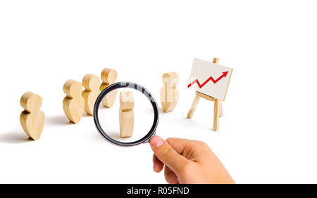 Lupe schaut sich die hölzernen Figuren von Menschen stehen in der Bildung und zu ihrem Führer hören. Business Training, Briefing und inspira Stockfoto