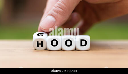 Hand dreht einen Würfel und Änderungen das Wort 'gut' zu 'Haube' Stockfoto