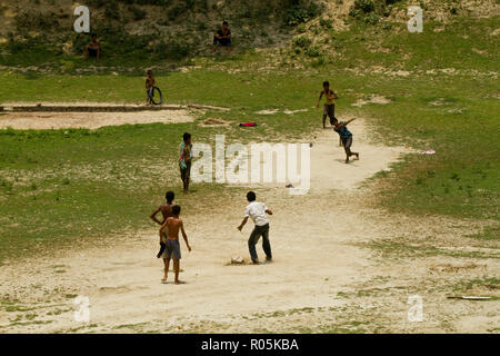Ländliche Kinder spielen Kricket im Feld. Dinajpur, Bangladesch. Stockfoto