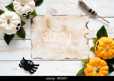 Blick von oben auf die alten Papier mit gelben Ghost pumpkins auf Holzbrett. halloween Konzept. Stockfoto