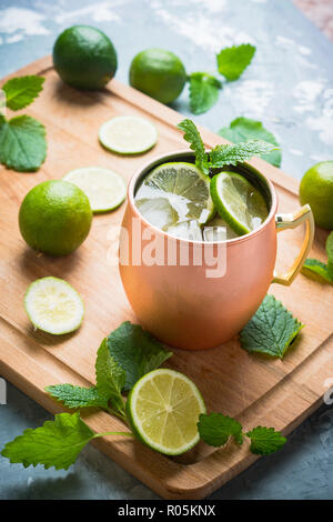 Kalte Moscow Mule Cocktail in Kupfer Becher auf der rustikalen Hintergrund. Geringe Tiefenschärfe. Stockfoto