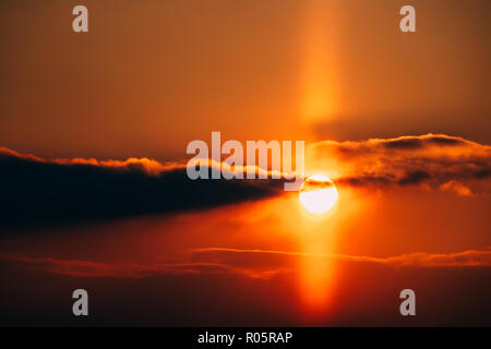 Natürliche sonnigen Licht Säule im Winter Sonnenuntergang. Atmosphärische optische Phänomen in Form einer vertikalen Band des Lichts, das erscheint Über zu verlängern und Stockfoto