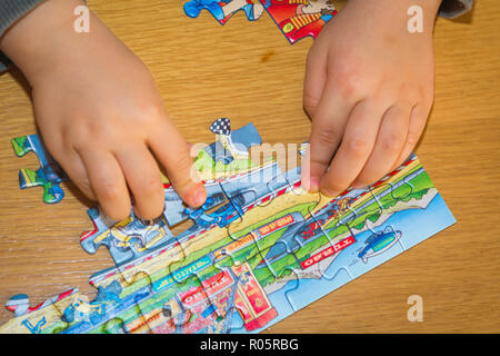 Baby Hände Zusammensetzen des Puzzles auf dem Tisch Stockfoto