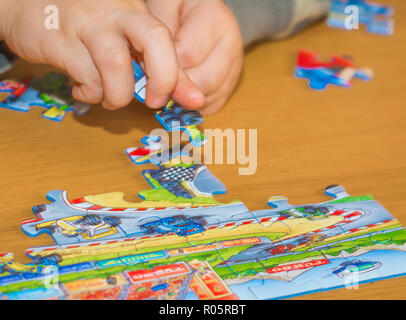 Baby Hände Zusammensetzen des Puzzles auf dem Tisch Stockfoto