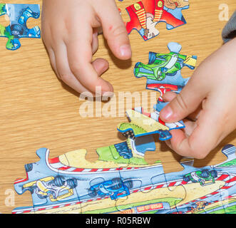 Baby Hände Zusammensetzen des Puzzles auf dem Tisch Stockfoto