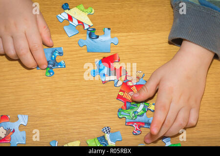 Baby Hände Zusammensetzen des Puzzles auf dem Tisch Stockfoto