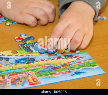 Baby Hände Zusammensetzen des Puzzles auf dem Tisch Stockfoto