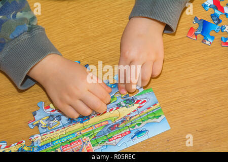 Baby Hände Zusammensetzen des Puzzles auf dem Tisch Stockfoto