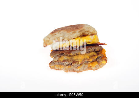 McDonald's neue Triple Stack egg mcmuffin Sandwich w/2 Würstchen 2 Streifen Speck 2 Scheiben American Käse auf Englisch muffin w Bissen genommen Stockfoto