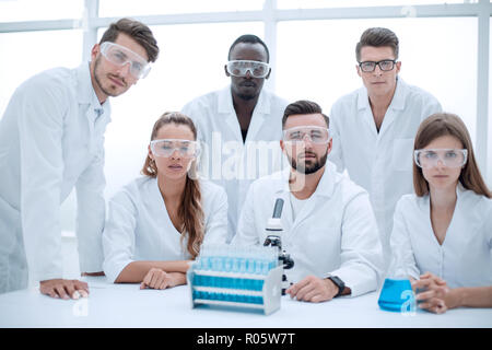 Eine Gruppe von Biologen auf der Suche nach einer Kamera, einer Präsentation von einer Gruppe von Wissenschaftlern in der wissenschaftlichen Forschung Labor der wissenschaftlichen Chemie Stockfoto