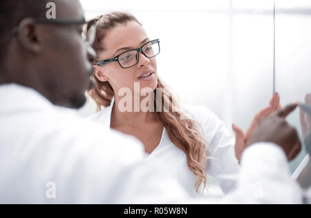 Attraktive junge Wissenschaftler Pipettieren und microscoping in der Life Science Forschung Labor Stockfoto