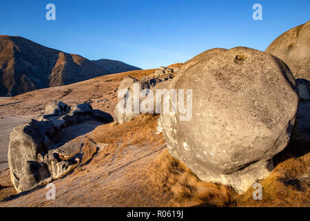 Ein riesiger Felsblock sitzt am Hang unter der Burg wie Felsen in das Tal bei Castle Hill, Neuseeland Stockfoto