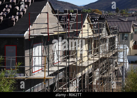 Mehrere neue zweigeschossige Einfamilienhäuser im Bau und Gerüstbau in einem Vorstädtischen neighorhood umgeben; gestapelt Dachziegel, diagonale Linien. Stockfoto