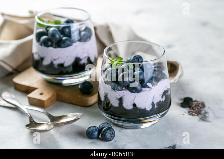 Detox Aktivkohle Chia pudding Frühstück mit Blaubeeren, Marmor Hintergrund Stockfoto