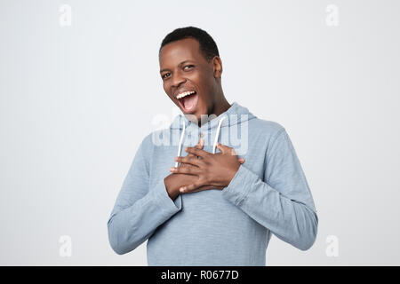 Afrikanischer Mann lächelnd und mit Blick auf die Kamera begeistert Stockfoto
