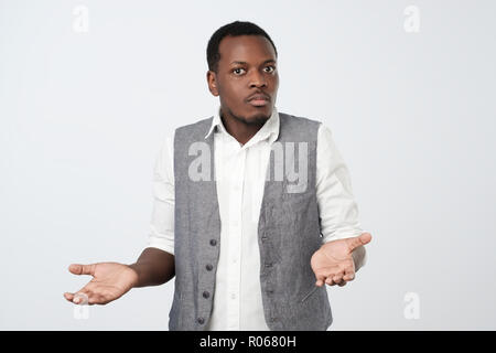 Junge afrikanische Mann im blauen Hemd zu einem Verlust, hilflose Geste mit Arm und Hand Stockfoto