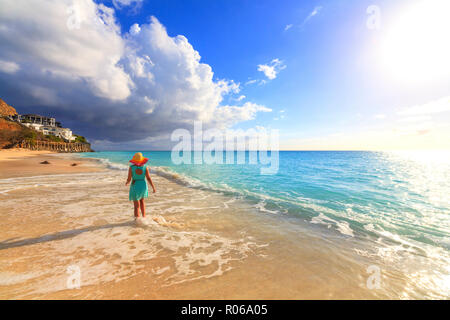 Ansicht der Rückseite Frau mit Hut gehen auf Ffryes Beach, Antigua, Antigua und Barbuda, Leeward Inseln, West Indies, Karibik, Zentral- und Lateinamerika Stockfoto