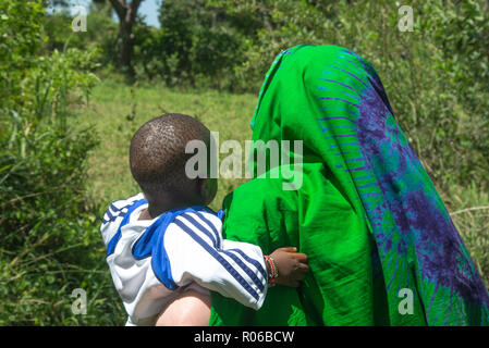 Mutter in Buntes Kleid mit Kind auf dem Arm in Kenia, Afrika Stockfoto