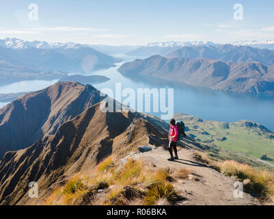 Frau Wanderer genießen die Aussicht vom Roys Peak Trail in der Nähe von Wanaka, Otago, Südinsel, Neuseeland, Pazifische Stockfoto