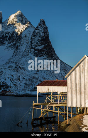 Alten hölzernen Boot Haus an der Waterfront, idyllische Lage und die malerische Aussicht auf die Berge See. Reinefjorden, Lofoten, Norwegen im Winter. Stockfoto