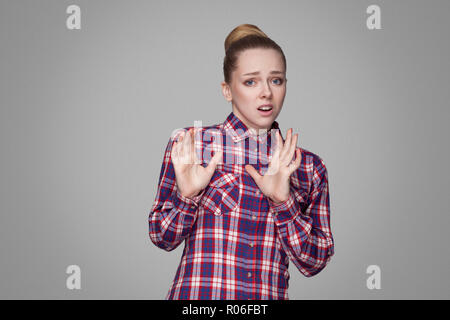 Schöne blonde Mädchen in Rot, Rosa kariertem Hemd Angst, sammelte bun Frisur, Make-up-stehen und von der Kamera, und versuchen Sie es zu blockieren. Stockfoto