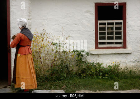 Junge Frau in Kleidung aus der Kolonialzeit gekleidet. Das Leben auf dem Bauernhof im 18. Jahrhundert. Irische Farm im Frontier Culture Museum in Staunton, VA, USA. Stockfoto